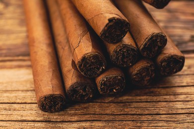 Cigars wrapped in tobacco leaves on wooden table, closeup