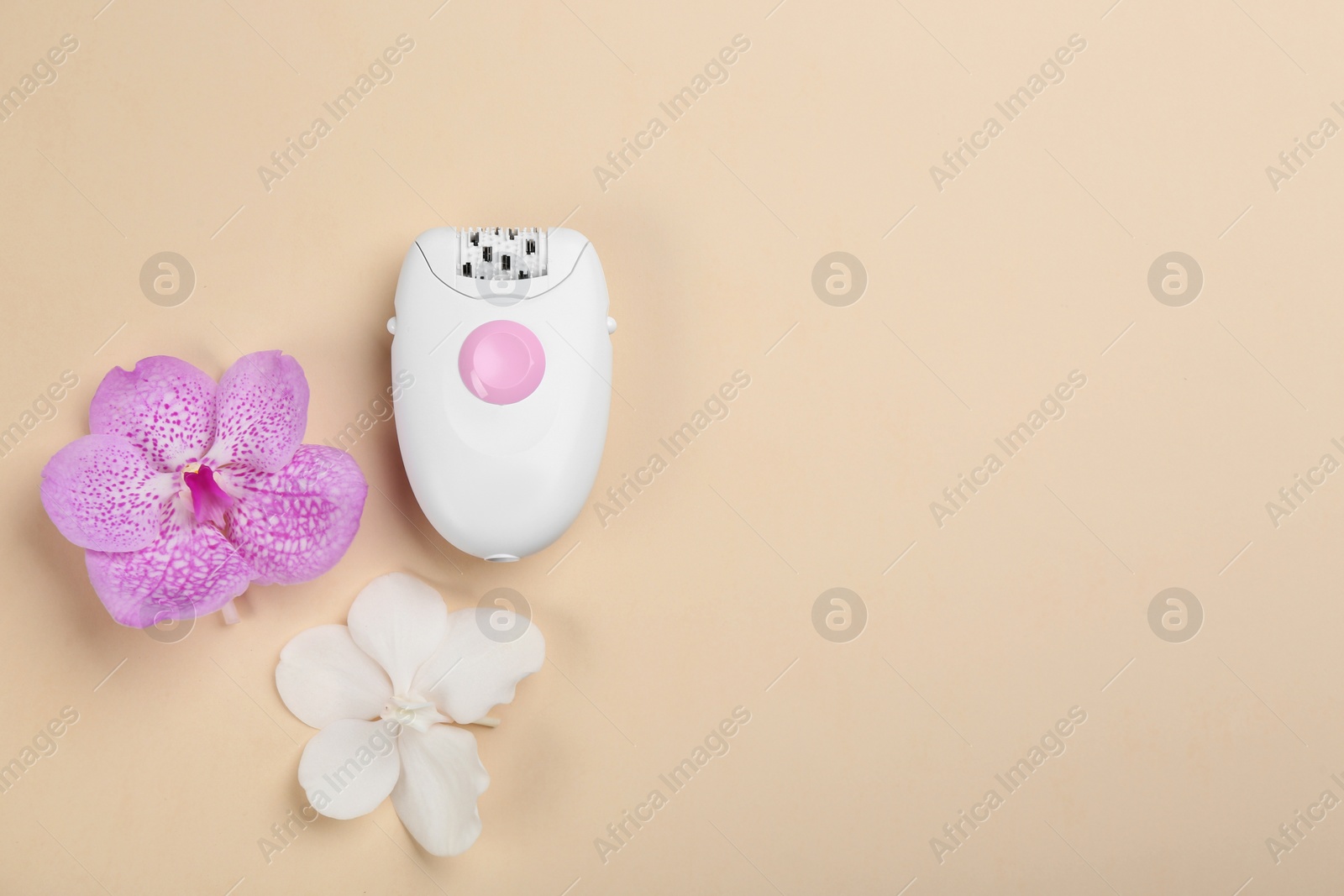 Image of Modern epilator and orchid flowers on beige background, top view. Space for text