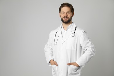 Doctor or medical assistant (male nurse) with stethoscope on light grey background