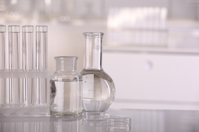 Photo of Laboratory analysis. Different glassware with liquid on white table indoors, space for text