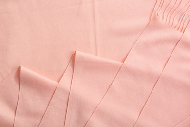 Elegant peach scarf as background, closeup view