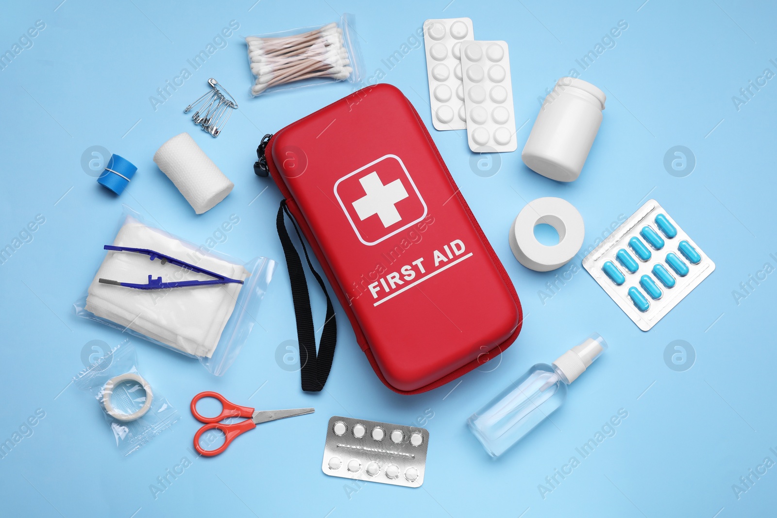 Photo of Flat lay composition with first aid kit on light blue background