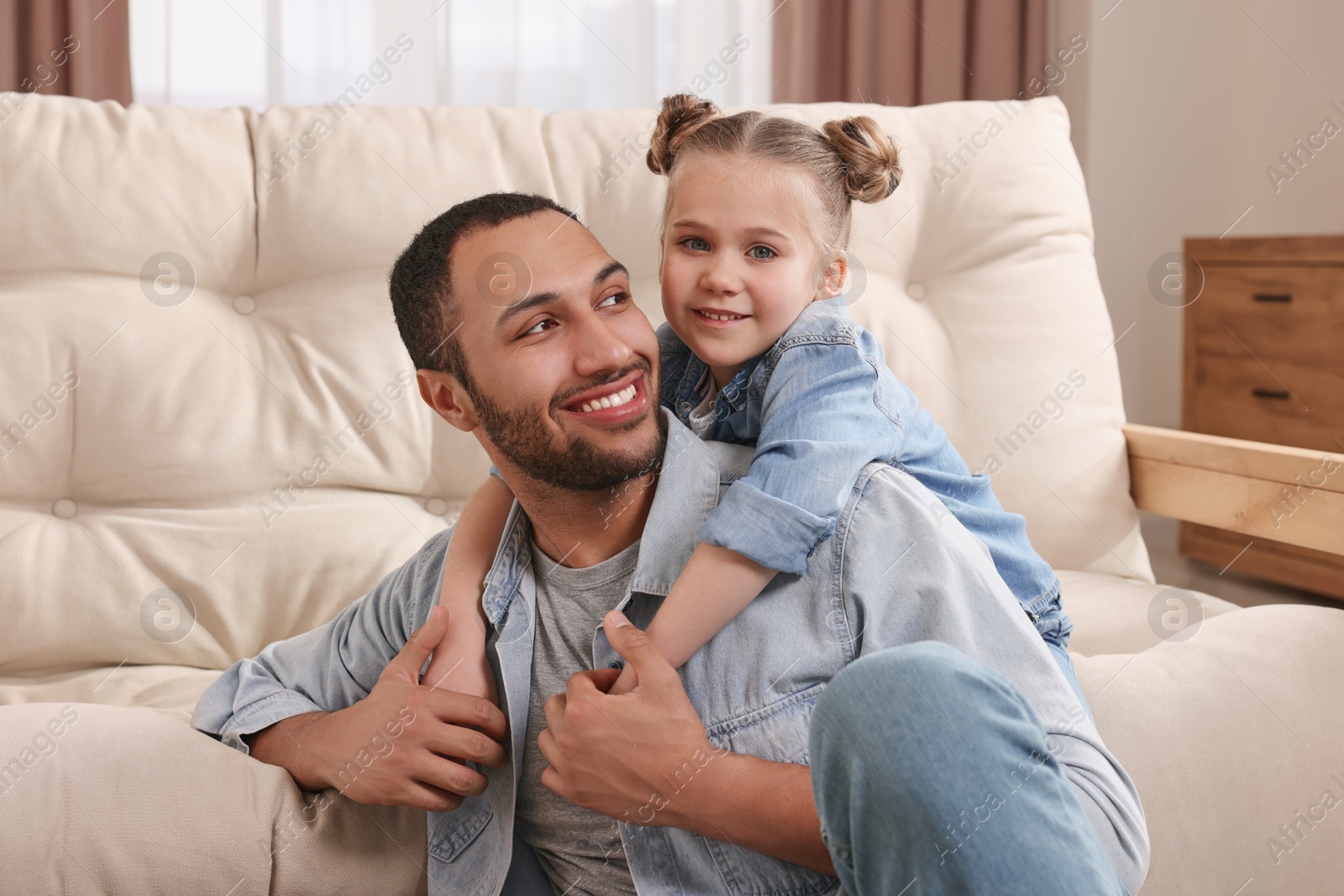 Photo of Little girl with her father spending time together at home. International family