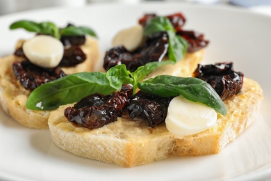 Photo of Delicious tomato bruschettas on white plate, closeup