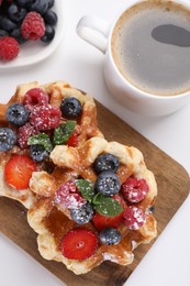 Photo of Delicious Belgian waffles with fresh berries on white table, flat lay