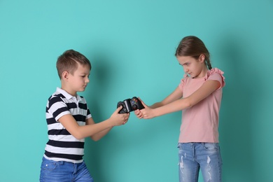 Brother arguing with sister on color background