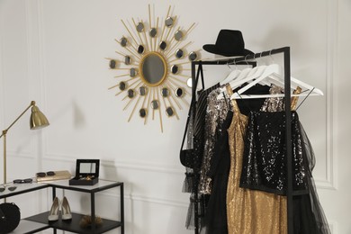 Rack with stylish women's clothes and accessories in dressing room