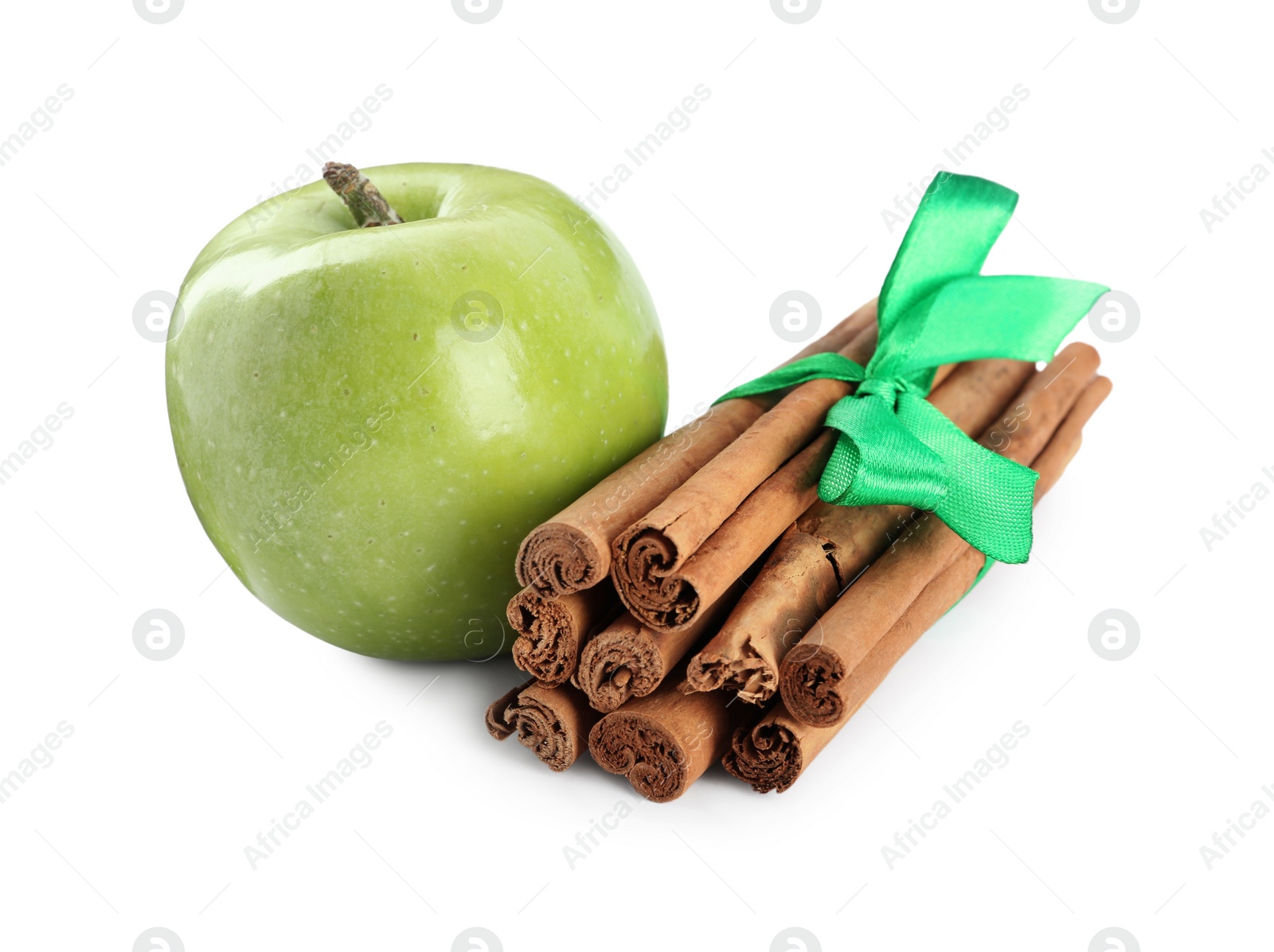 Photo of Cinnamon sticks and green apple on white background