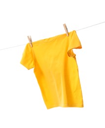 Photo of One yellow t-shirt drying on washing line isolated on white