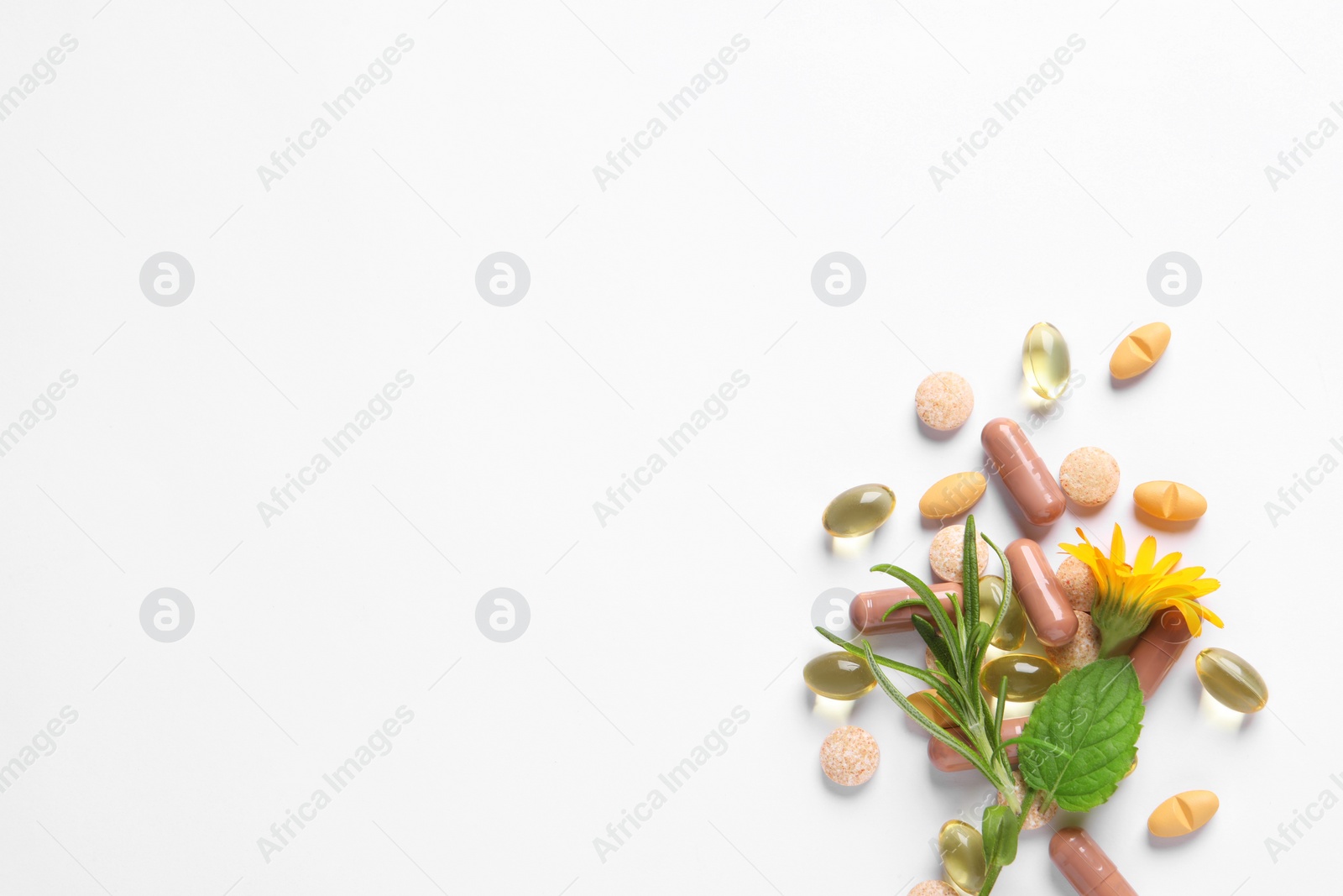 Photo of Different pills, herbs and flower on white background, flat lay with space for text. Dietary supplements