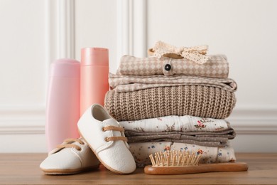 Photo of Baby clothes, shoes and accessories on wooden table