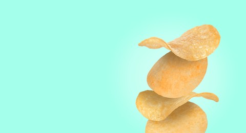 Stack of tasty potato chips on turquoise background, space for text
