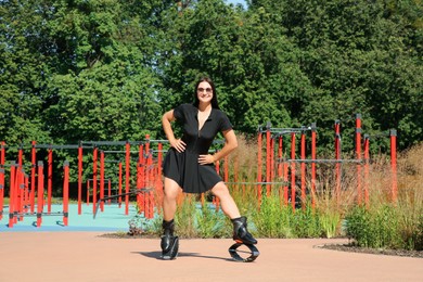 Photo of Woman doing exercises in kangoo jumping boots in workout park
