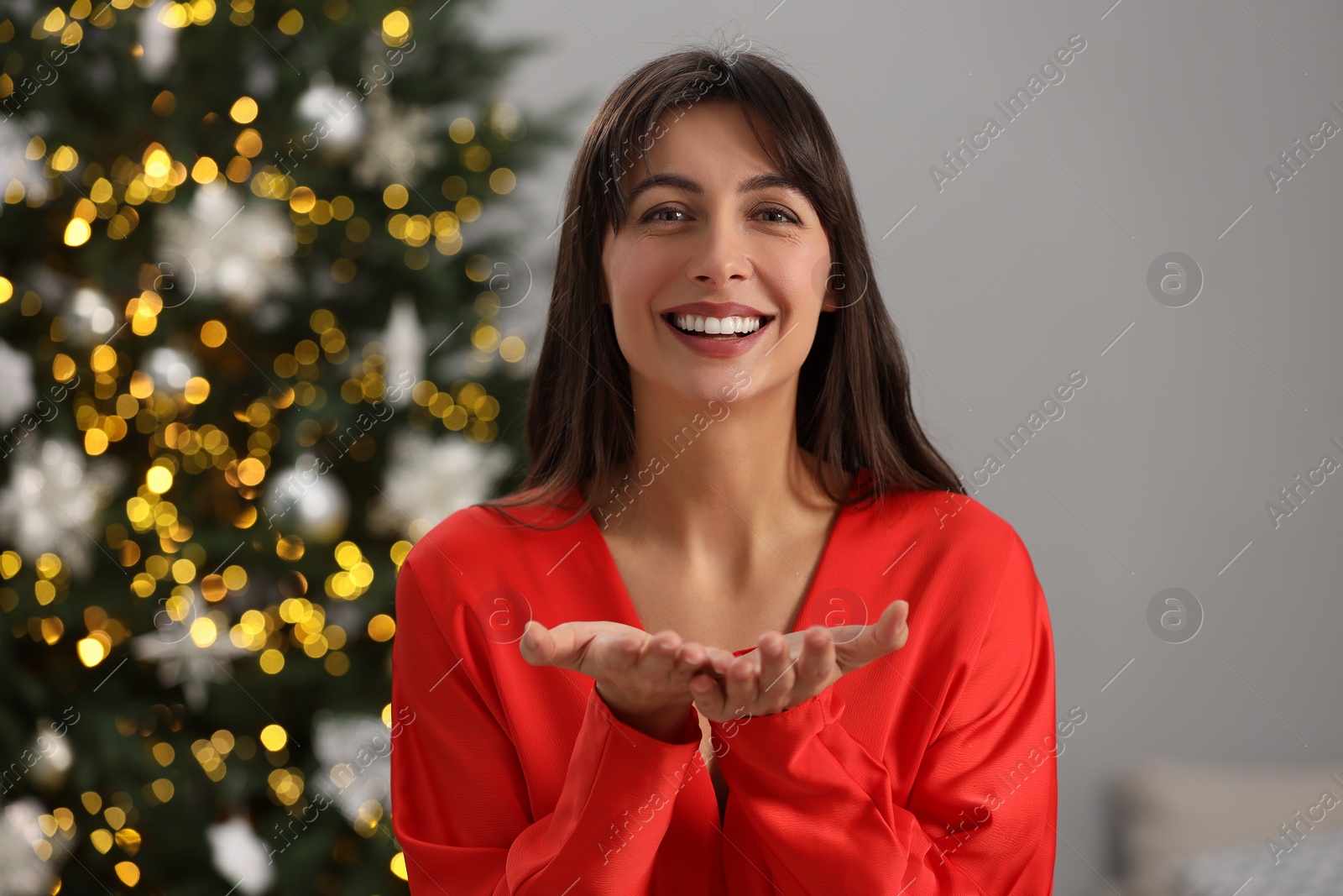 Photo of Portrait of smiling woman in room with Christmas decorations