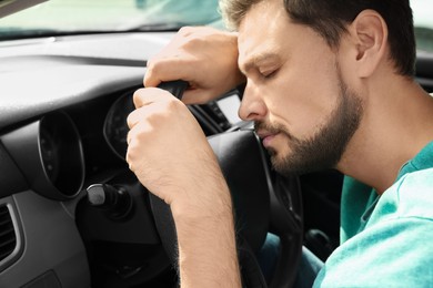 Tired man sleeping in his modern car, closeup