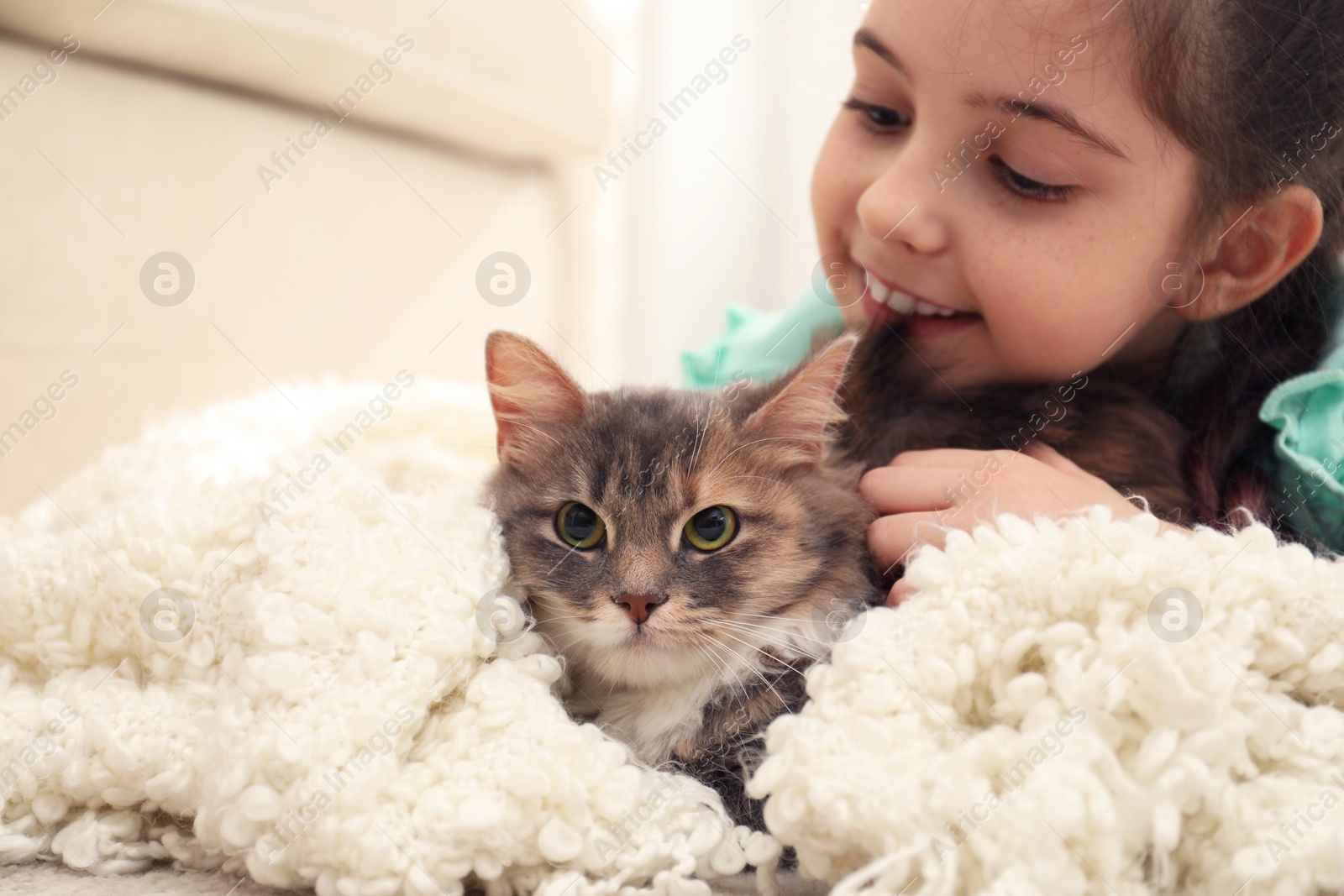 Photo of Cute little girl with cat at home, closeup. First pet