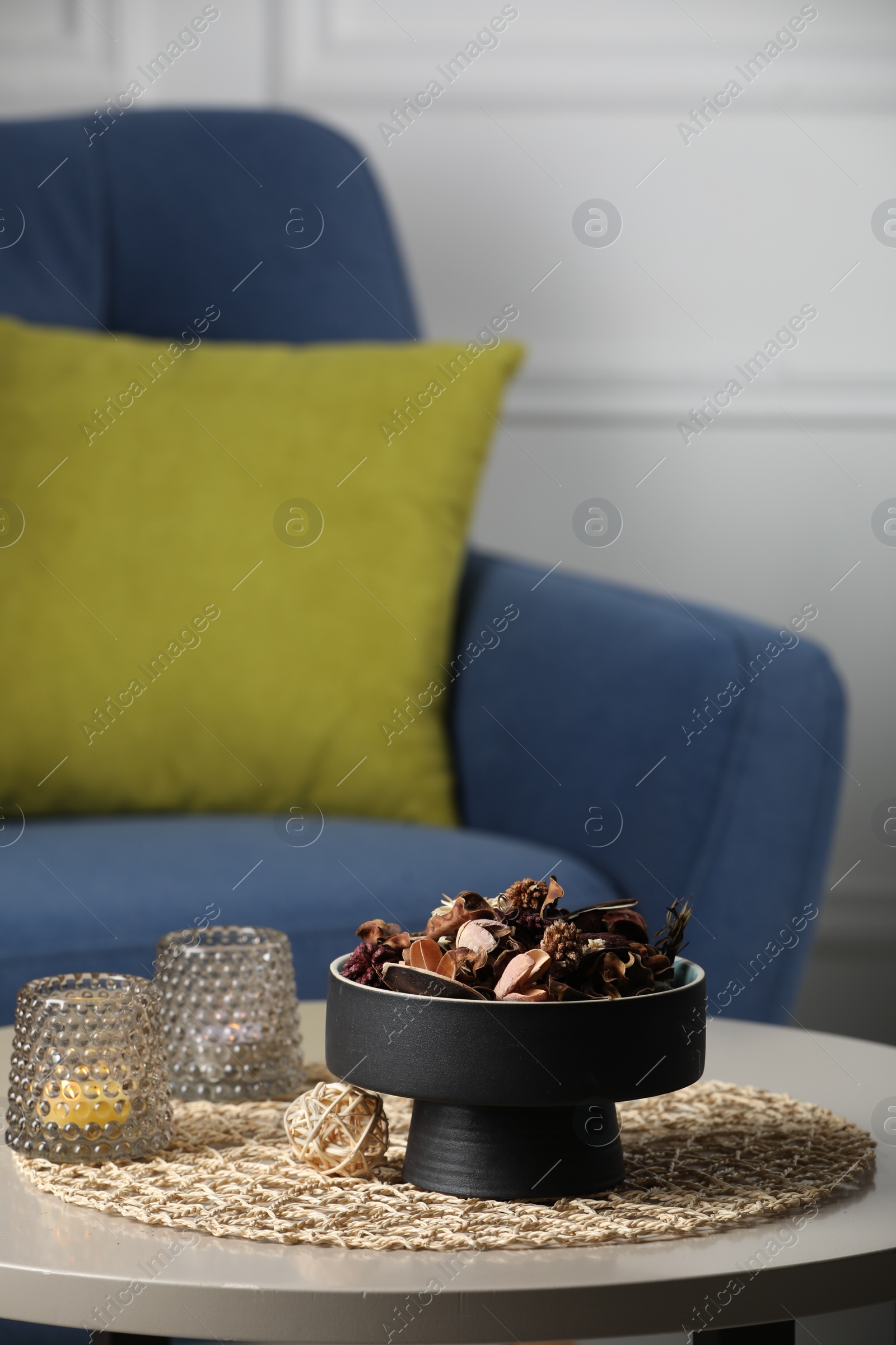 Photo of Aromatic potpourri of dried flowers and burning candles on table indoors