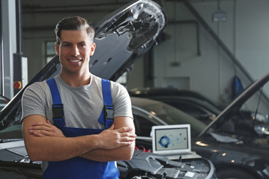 Photo of Mechanic near automobile in service center, space for text. Car diagnostic
