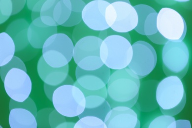 Photo of Blurred view of beautiful lights on green background