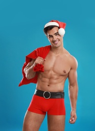 Sexy shirtless Santa Claus on blue background