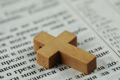 MYKOLAIV, UKRAINE - DECEMBER 21, 2021: Wooden cross on Bible, closeup. Text in russian