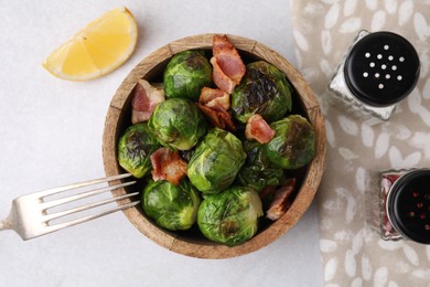 Delicious roasted Brussels sprouts and bacon served on light table, top view