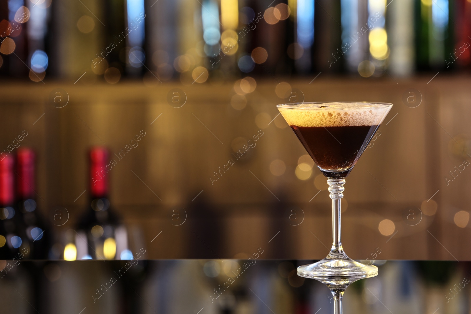 Photo of Glass of delicious Espresso Martini on bar counter, space for text. Alcohol cocktail