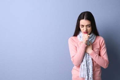 Photo of Young woman coughing on color background