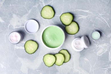 Flat lay composition with jars of body cream on grey marble background