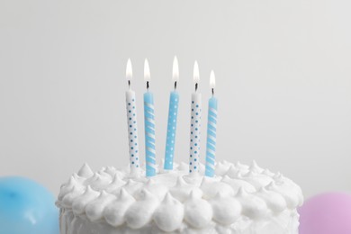 Photo of Delicious cake with cream and burning candles on white background, closeup