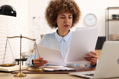 Photo of Notary working with documents at workplace in office