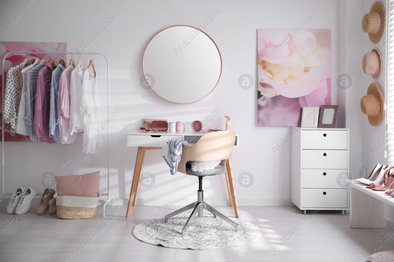 Photo of Dressing room interior with stylish makeup table, clothes and accessories