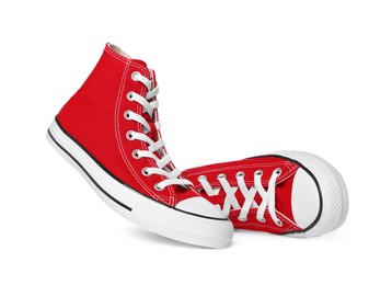 Pair of new red stylish high top plimsolls on white background