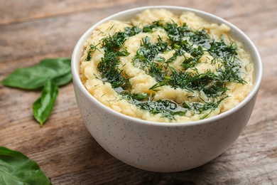 Photo of Bowl with tasty mashed potato on wooden table