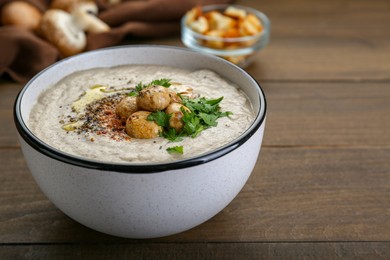 Photo of Delicious cream soup with mushrooms on wooden table