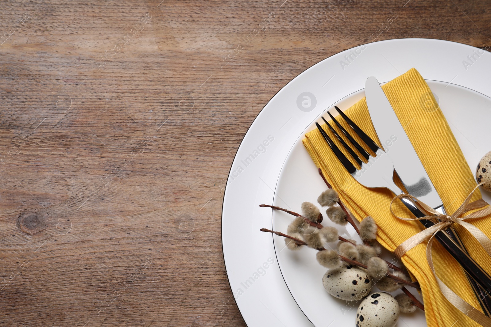 Photo of Festive Easter table setting with eggs on wooden background, top view. Space for text