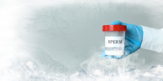 Image of Cryopreservation. Scientist holding container with sperm on color background, closeup and space for text. Frost effect