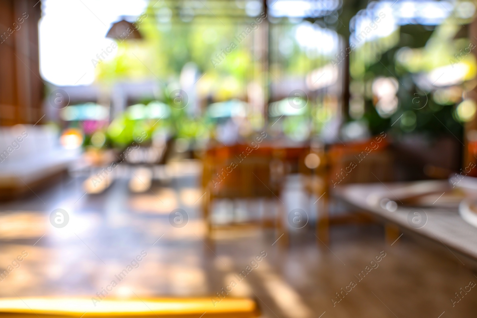 Photo of Blurred view of comfortable cafeteria with furniture