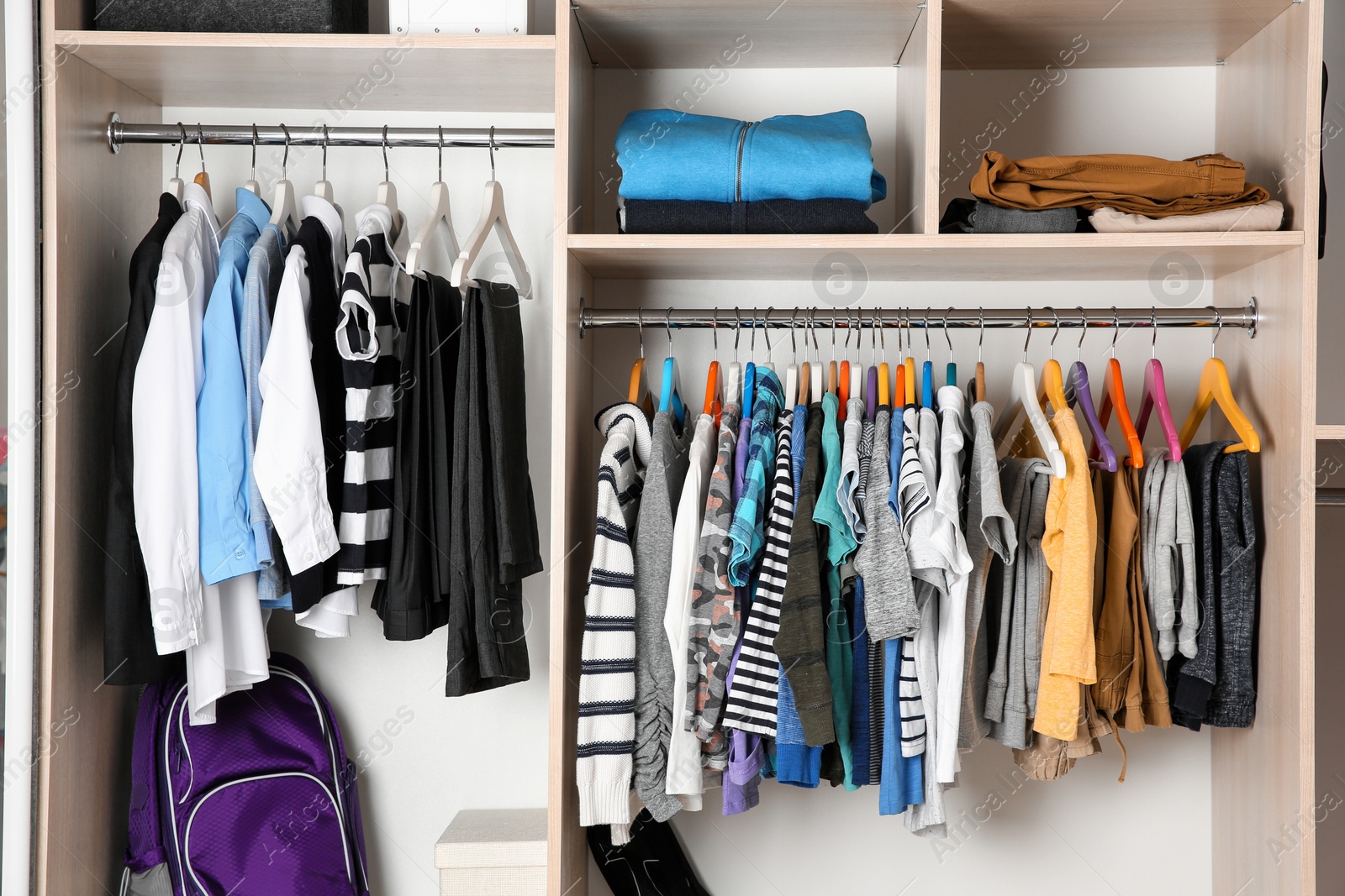 Photo of Wardrobe with stylish boy's clothes hanging on rack