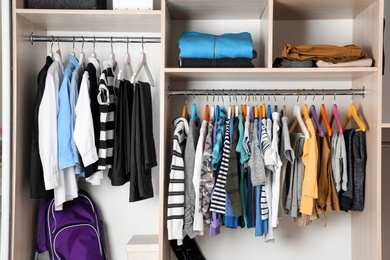 Wardrobe with stylish boy's clothes hanging on rack