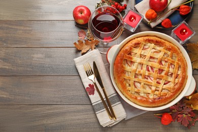 Photo of Delicious homemade apple pie and autumn decor on wooden table, flat lay. Space for text