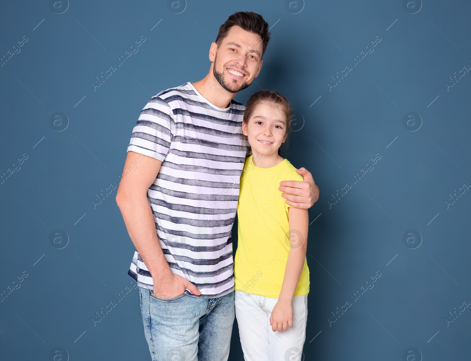 Photo of Dad and his daughter hugging on color background. Father's day celebration