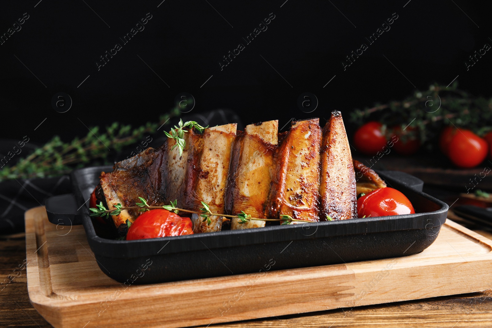 Photo of Delicious roasted ribs served on wooden table