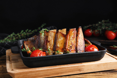 Photo of Delicious roasted ribs served on wooden table