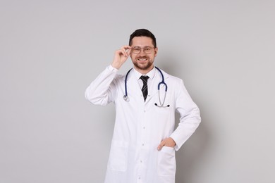 Photo of Portrait of smiling doctor on light grey background