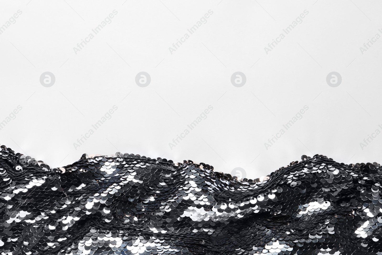 Photo of Beautiful bright sequin fabric on white background, top view. Space for text