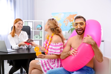 Beautiful young couple visiting travel agency office