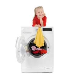 Photo of Cute little girl on washing machine with laundry against white background