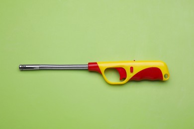 Photo of One gas lighter on green background, top view