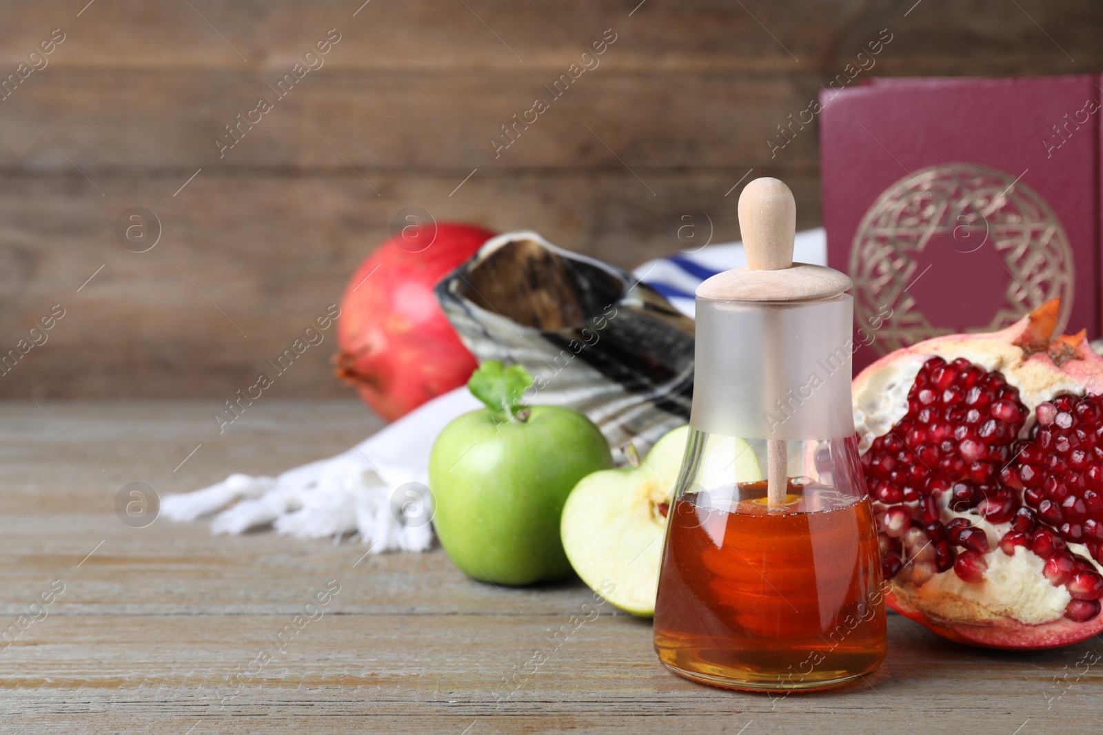 Photo of Honey, pomegranate, apples, shofar and Torah on wooden table. Rosh Hashana holiday